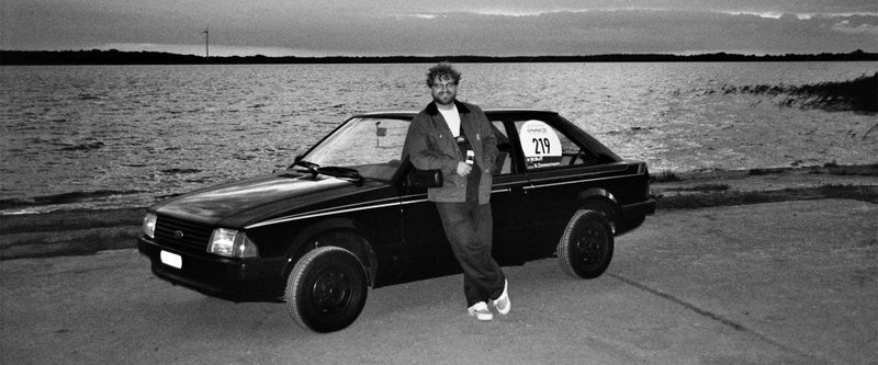 Wolfgang Muff von den MediaMechs vor einem Ford Escort MK3 an der Creme21