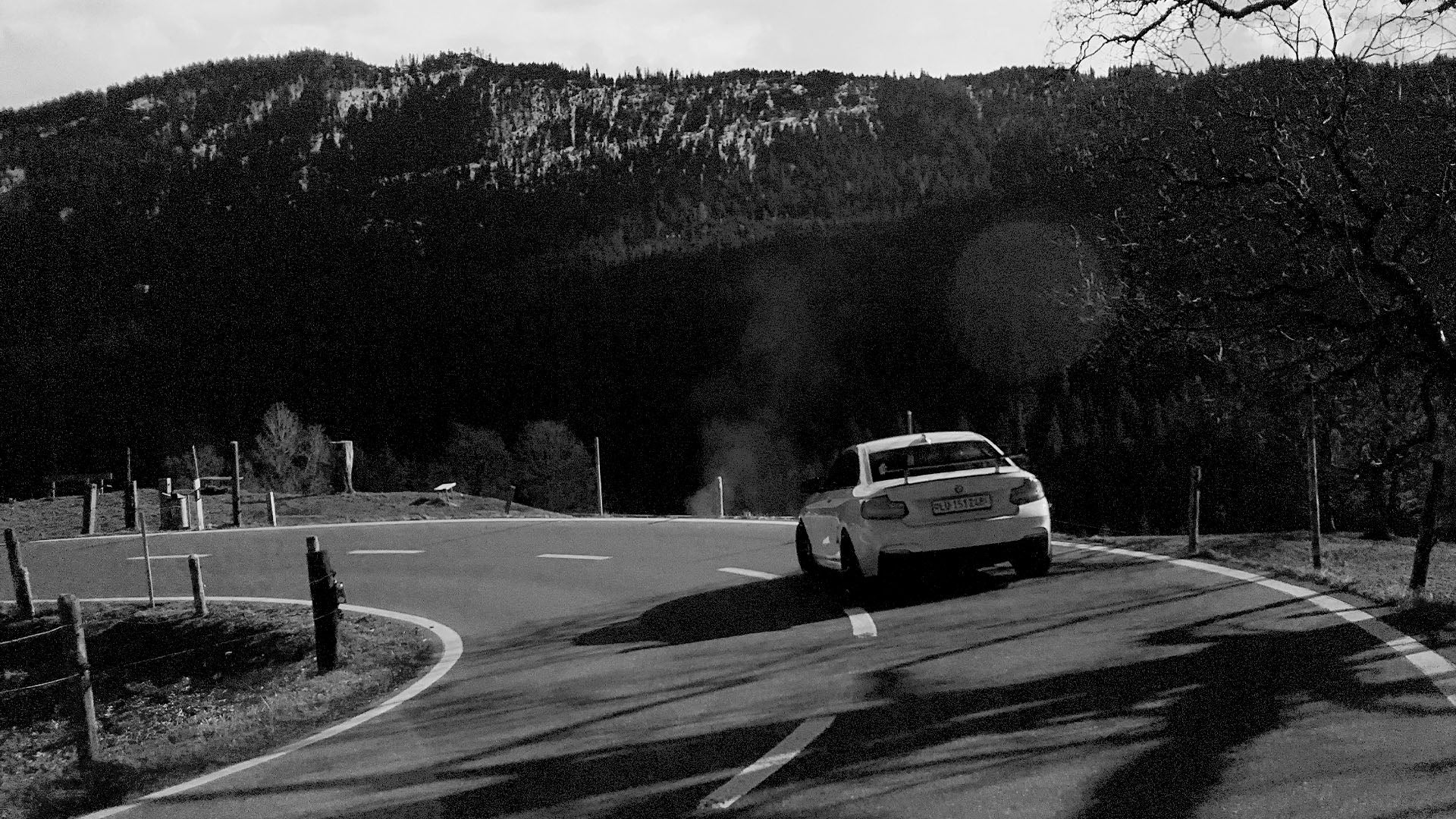 Professionell in Szene gesetztes weißes BMW M Coupé auf einer kurvenreichen Passstraße in der Schweiz, ein kraftvolles Bild für Ihr Fahrzeug-Marketing